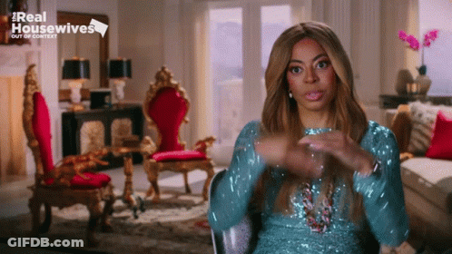 Woman In Blue Sequined Dress Sitting In Living Room GIF