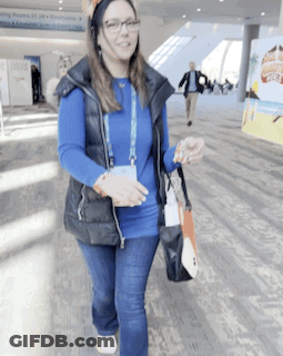 Woman In Blue Shirt And Black Vest Walking GIF