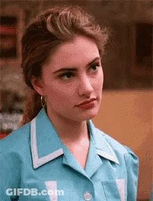 Woman In Blue Shirt And Earrings Making Funny Face GIF