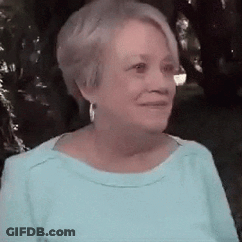 Woman In Blue Shirt And Earrings Smiling GIF