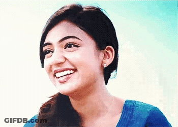 Woman In Blue Shirt And Earrings Smiling GIF
