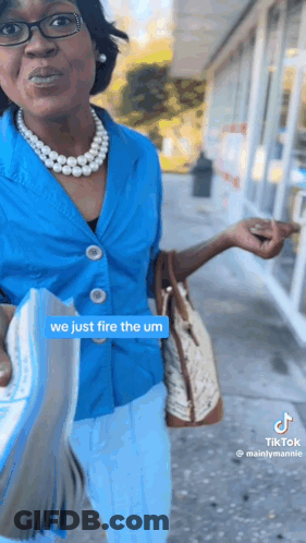 Woman In Blue Shirt And Pearls Holding Book GIF