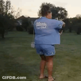 Woman In Blue Shirt And Shorts In Grassy Field GIF