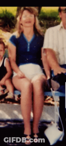 Woman In Blue Shirt And White Shorts Sitting With Man And Child GIF