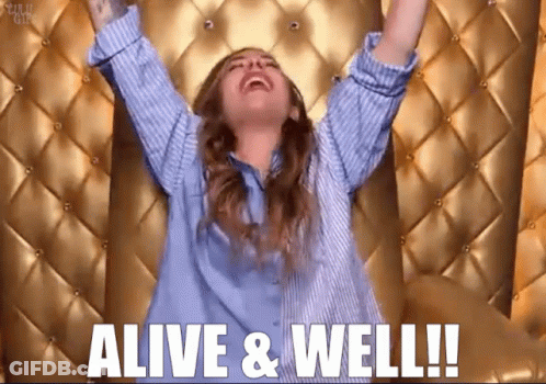 Woman In Blue Shirt Arms In Air Alive & Well GIF