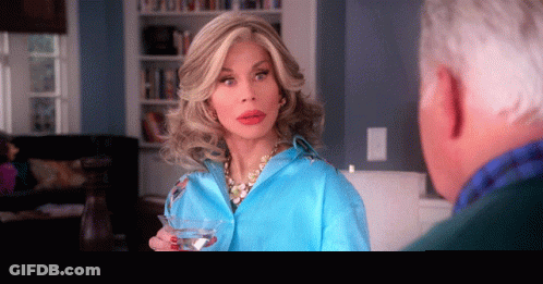Woman In Blue Shirt Holding Martini GIF