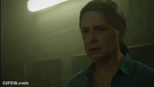 Woman In Blue Shirt In Dark Room With Green Light GIF