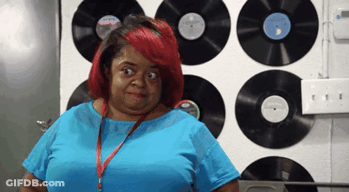 Woman In Blue Shirt In Front Of Record Wall GIF