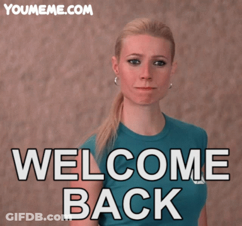 Woman In Blue Shirt In Front Of Welcome Back Sign GIF