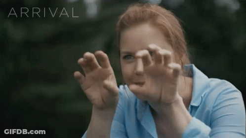 Woman In Blue Shirt Looking Through Glass Arrival GIF