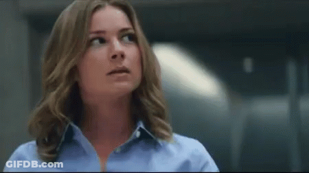Woman In Blue Shirt Looking Up In Dark Room GIF