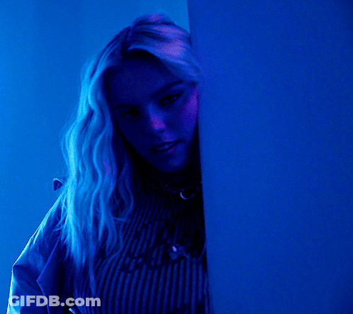 Woman In Blue Shirt Peeking From Behind Blue Wall GIF