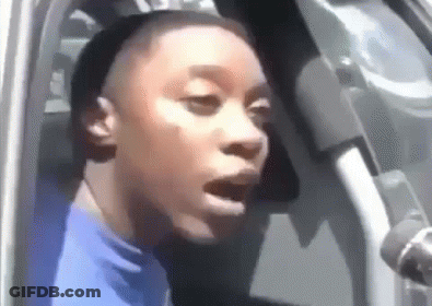 Woman In Blue Shirt Sitting In Car With Mouth Open GIF