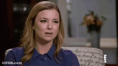 Woman In Blue Shirt Sitting In Chair With Letter E GIF