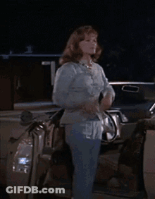 Woman In Blue Shirt Standing Next To Car At Night GIF