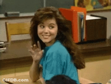 Woman In Blue Shirt Waving At Desk GIF