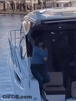 Woman In Blue Shirt With Arms Up On Boat GIF