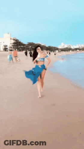 Woman In Blue Skirt Running Into Ocean GIF