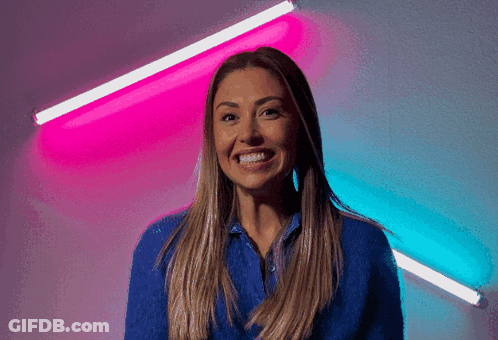 Woman In Blue Smiling In Front Of Pink And Blue Background GIF