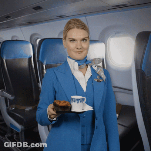 Woman In Blue Suit Holding Food And Coffee GIF