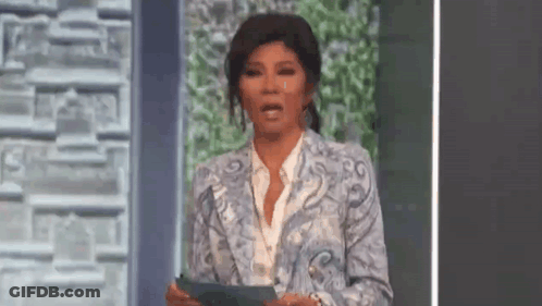 Woman In Blue Suit Holding Paper And Making Face GIF
