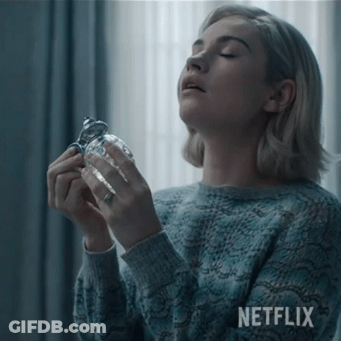 Woman In Blue Sweater Holding Glass With Netflix GIF