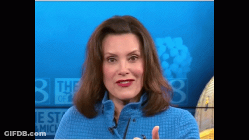 Woman In Blue Sweater In Front Of Sign Saying The 3 Best Of Michigan GIF