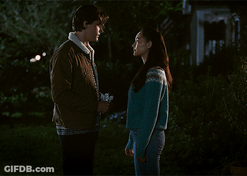 Woman In Blue Sweater Kissing Man In Brown Jacket GIF