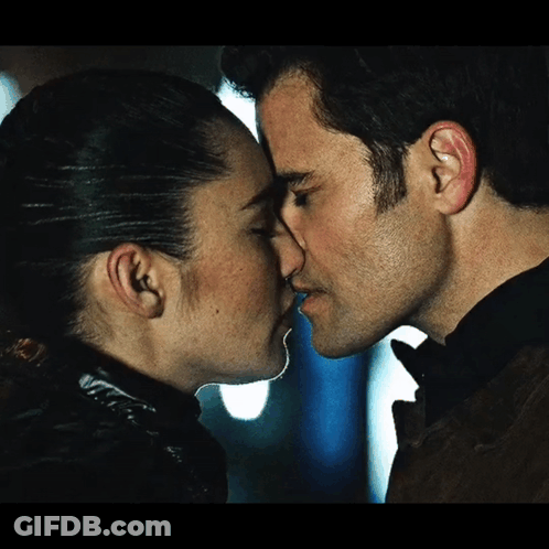 Woman In Blue Sweater Kissing Man In Brown Jacket GIF