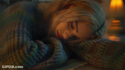 Woman In Blue Sweater Laying On Stomach GIF