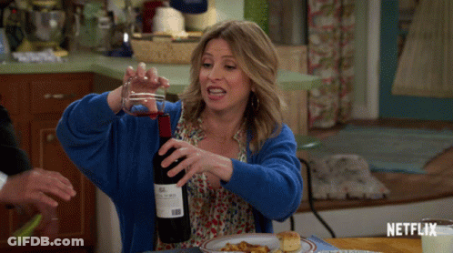 Woman In Blue Sweater Pouring Wine GIF
