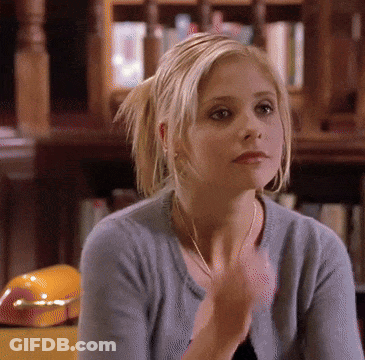 Woman In Blue Sweater Sitting In Front Of Bookcase GIF
