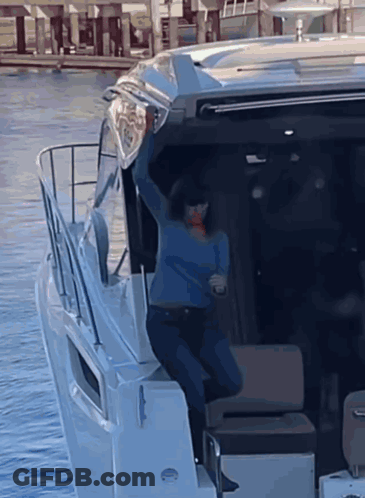 Woman In Blue Sweater Standing On Boat GIF