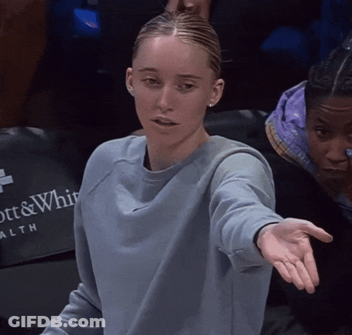 Woman In Blue Sweatshirt Sitting In Front Of Ott & Whitaker Health Sign GIF