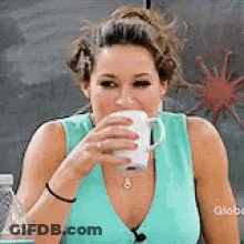 Woman In Blue Tank Top Drinking From Cup GIF