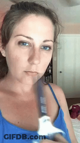 Woman In Blue Tank Top Holding White Object GIF