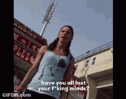 Woman In Blue Tank Top In Front Of Plesco Sign GIF