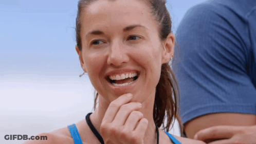 Woman In Blue Tank Top Smiling Hand To Chin GIF