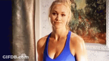 Woman In Blue Tank Top Smiling In Front Of Painting GIF