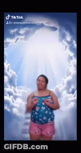 Woman In Blue Top And Pink Shorts Under Cloudy Sky GIF