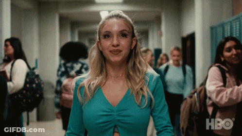 Woman In Blue Top Walking Down Hallway With HBO Logo GIF