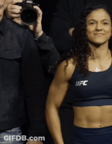 Woman In Blue UFC Top In Front Of Man Holding Camera GIF