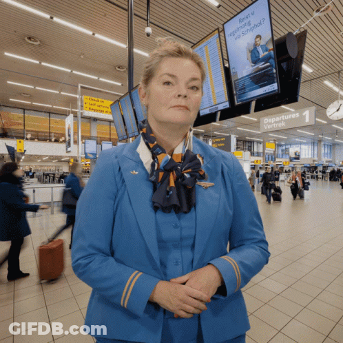Woman In Blue Uniform At Departures Sign GIF