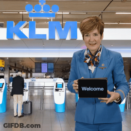 Woman In Blue Uniform Holding Tablet Saying Welcome GIF