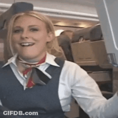 Woman In Blue Vest Smiling On Airplane GIF