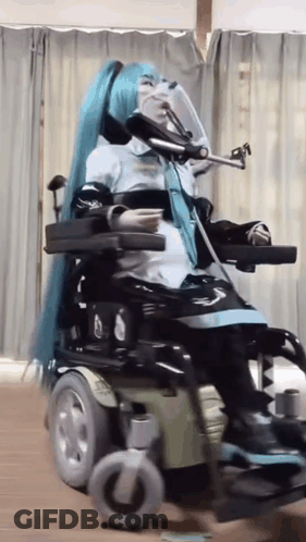 Woman In Blue Wig Sitting In Wheelchair GIF