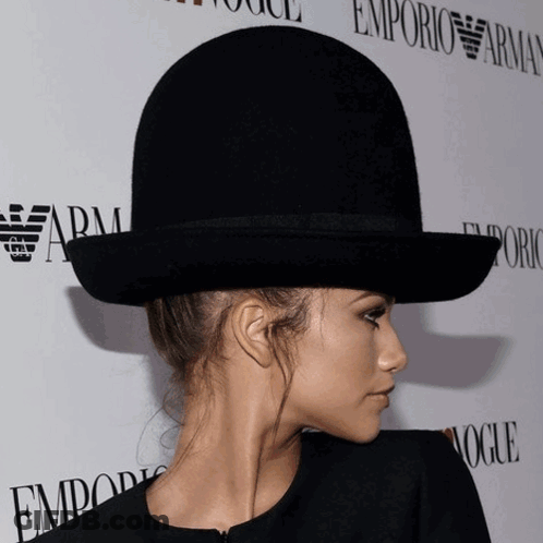 Woman In Bowler Hat In Front Of Emporio Armani Sign GIF
