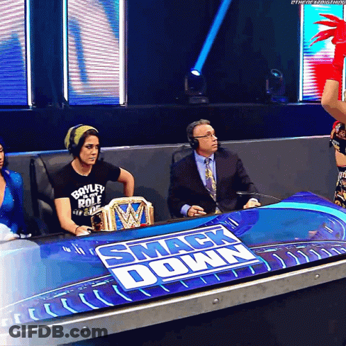 Woman In Boyley Role Shirt Sits At Smack Down Table GIF