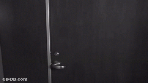 Woman In Bra Standing By Door GIF