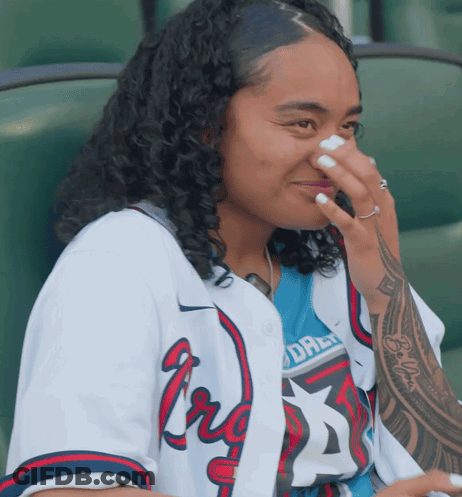 Woman In Braves Jersey Covering Nose GIF